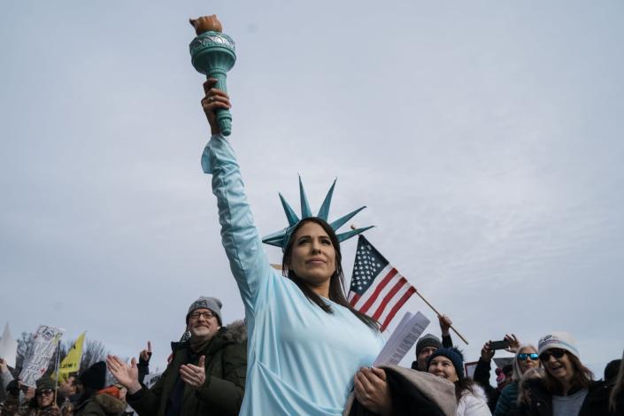 A woman dressed as the Statue of Liberty poses during a Defeat the Mandates Rally on the National Mall.