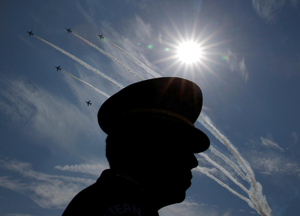 SDF official is silhouetted while flights performs air show