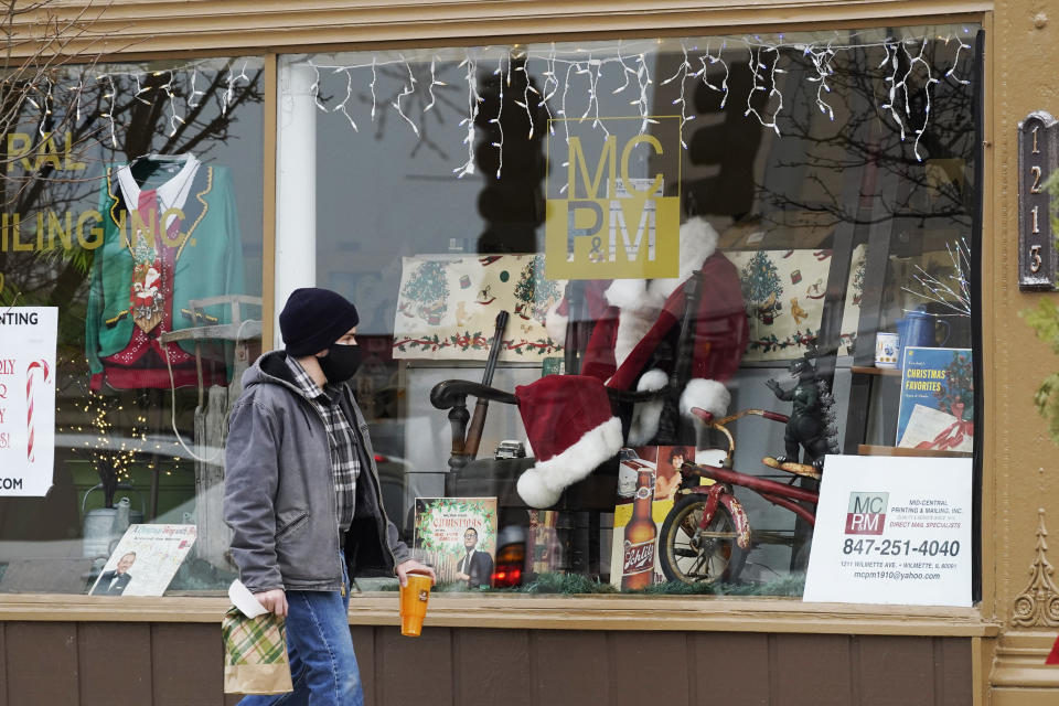 Christmas cards and costumes are displayed in the window at Mid Central Printing & Mailing store in Wilmette, Ill., Friday, Dec. 18, 2020. Isolated by the coronavirus pandemic, Americans are sending more Christmas and holiday cards to stay in touch this year. (AP Photo/Nam Y. Huh)