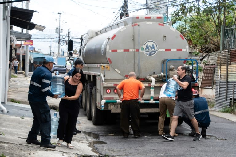 Unos vecinos de un barrio de San José recolectan agua de un camión cisterna el 26 de enero de 2024 (Ezequiel Becerra)