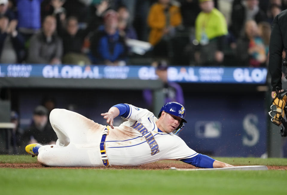 Seattle Mariners' Ty France slides to score on a single by Jarred Kelenic against the Colorado Rockies during the sixth inning of a baseball game Sunday, April 16, 2023, in Seattle. (AP Photo/Lindsey Wasson)