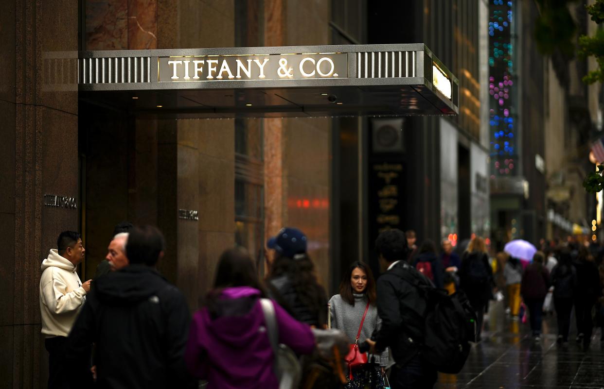 People walk past the headquarters of  luxury jewelry and specialty retailer Tiffany & Co on 5th Avenue in Manhattan on October 27, 2019 in New York City. - LVMH, the French owner of Louis Vuitton, is exploring a takeover of Tiffany & Co to expand in the US jewelry market, according to reports. (Photo by Johannes EISELE / AFP) (Photo by JOHANNES EISELE/AFP via Getty Images)