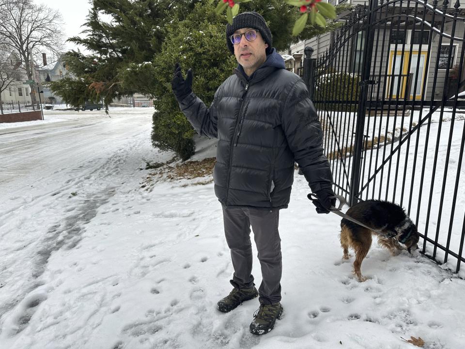 Joshua Phillips speaks with a reporter while walking his dog Maddie in the snow, Thursday, Jan. 18, 2024 in Memphis, Tenn. (AP Photo/Adrian Sainz)