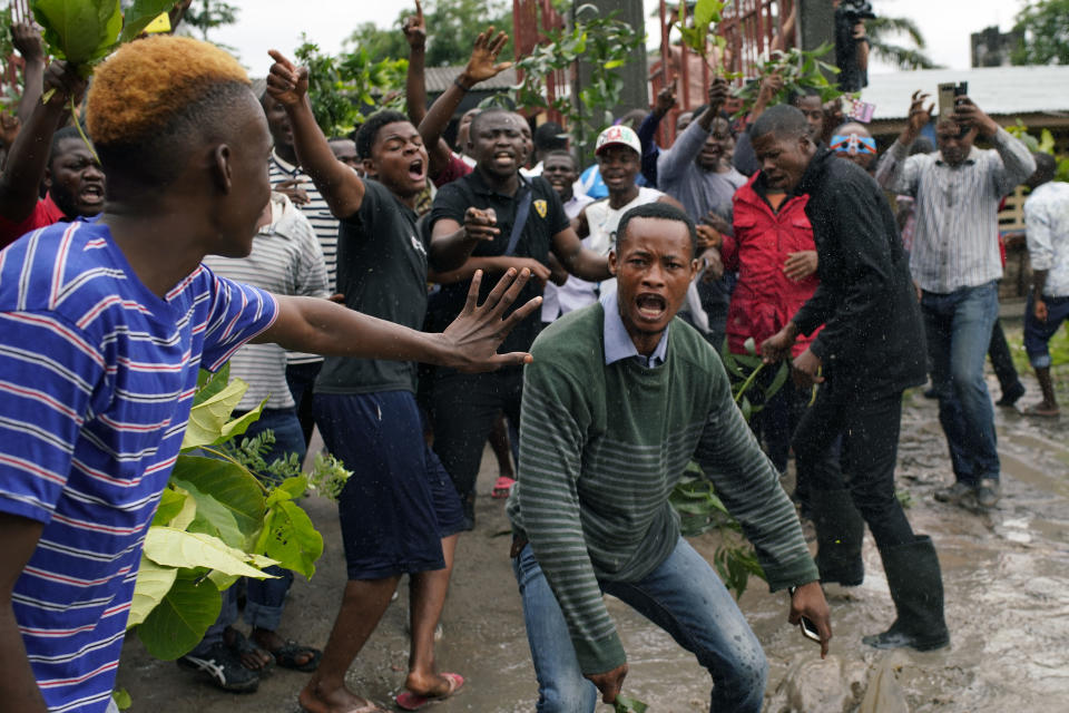 Congolese voters who have been waiting at the St. Raphael school in the Limete district of Kinshasa Sunday Dec. 30, 2018, heckle Corneille Nangaa, the president of the independent electoral commission (CENI) as he arrives to deliver the voters listings. People had started to gather at 6am to cast their votes, and four hours later, vote had not started as the lists were not available. Forty million voters are registered for a presidential race plagued by years of delay and persistent rumors of lack of preparation. (AP Photo/Jerome Delay)