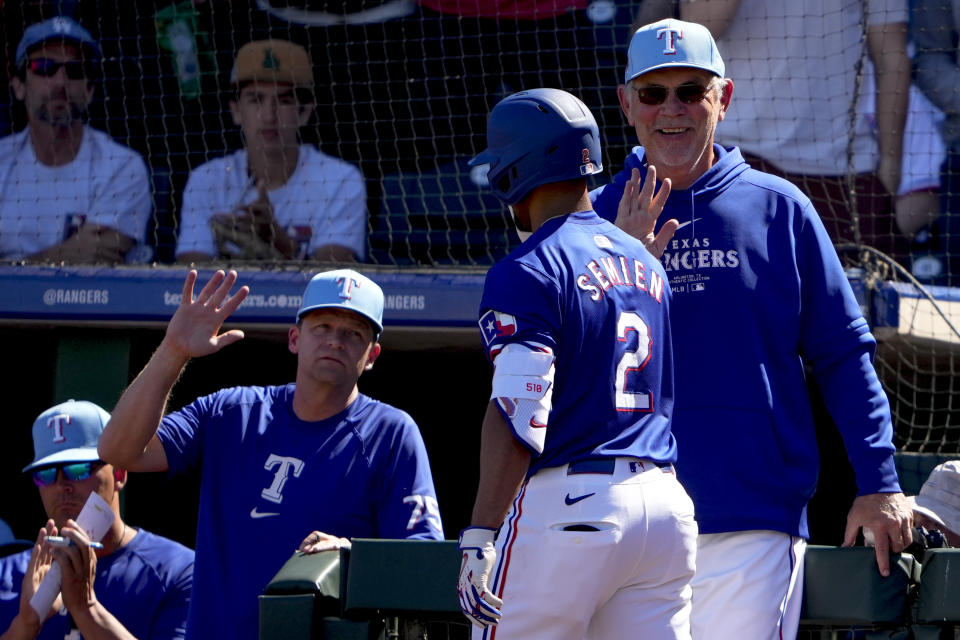 Marcus Semien (2) de los Rangers de Texas es felicitado por el mánager Bruce Bochy (derecha) tras batear un jonrón ante los Angelinos de Los Ángeles, el 4 de marzo de 2024, en Surprise, Arizona. (AP Foto/Lindsey Wasson)