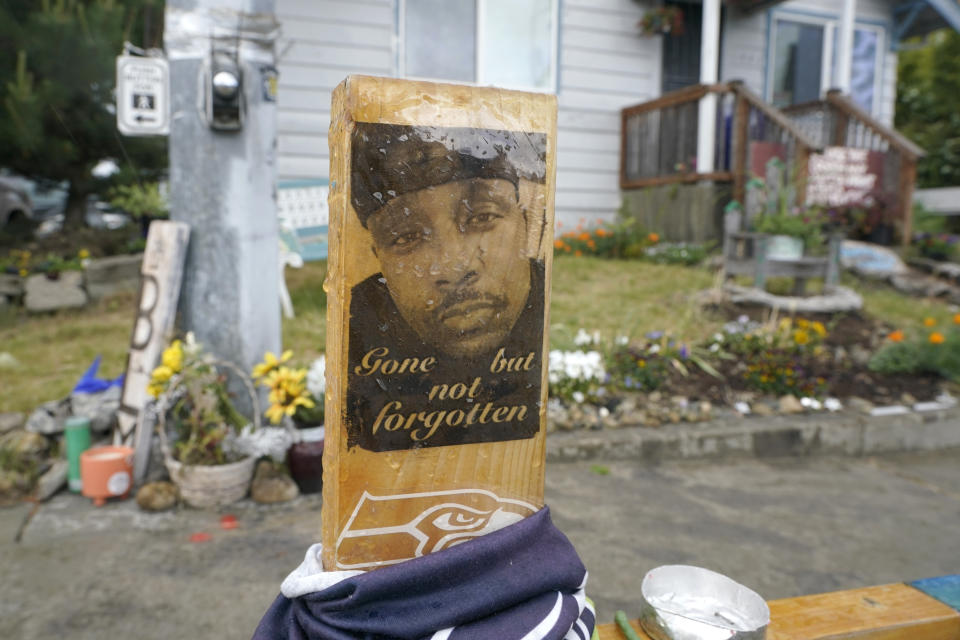 FILE - A sign is displayed on May 27, 2021, at a memorial in Tacoma, Wash., where Manuel "Manny" Ellis died on March 3, 2020, after he was restrained by police officers. Timothy Rankine, one of the Washington state police officers cleared of criminal charges in the 2020 death of Ellis — a Black man who was shocked, beaten and restrained facedown on a sidewalk as he pleaded for breath — is taking steps to sue local and state officials for $94 million over alleged defamation. (AP Photo/Ted S. Warren, File)