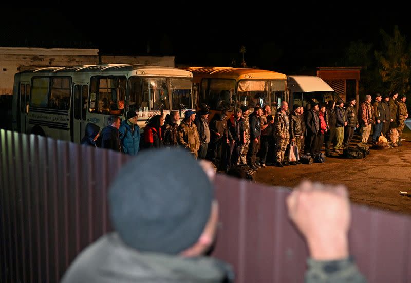 Reservists drafted during the partial mobilisation line up outside a recruitment office in Tara