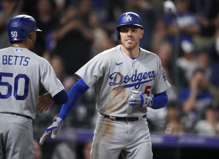 Los Angeles Dodgers' Mookie Betts, left, congratulates Freddie Freeman for a three-run home run off Colorado Rockies relief pitcher Justin Lawrence during the eighth inning of a baseball game Wednesday, Sept. 27, 2023, in Denver. (AP Photo/David Zalubowski)