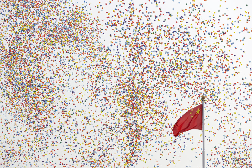 Balloons float past a Chinese flag on Tiananmen Square after being released during a parade commemorating the 70th anniversary of the founding of Communist China in Beijing, Tuesday, Oct. 1, 2019. Trucks carrying weapons including a nuclear-armed missile designed to evade U.S. defenses rumbled through Beijing as the Communist Party celebrated its 70th anniversary in power with a parade Tuesday that showcased China's ambition as a rising global force. (AP Photo/Mark Schiefelbein)
