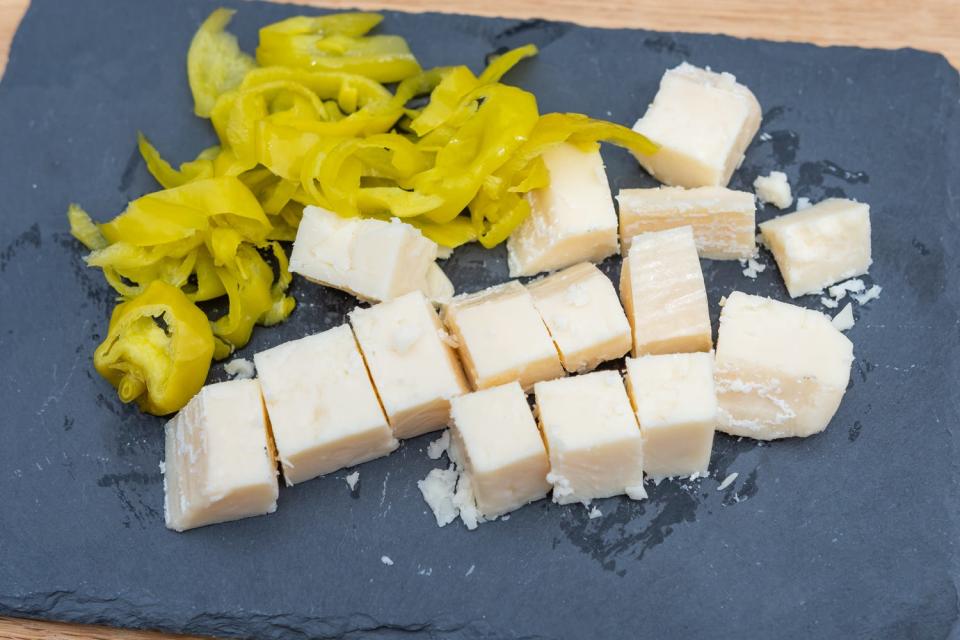 beechers cheese in cubes next to chopped pepperoncini on cutitng board