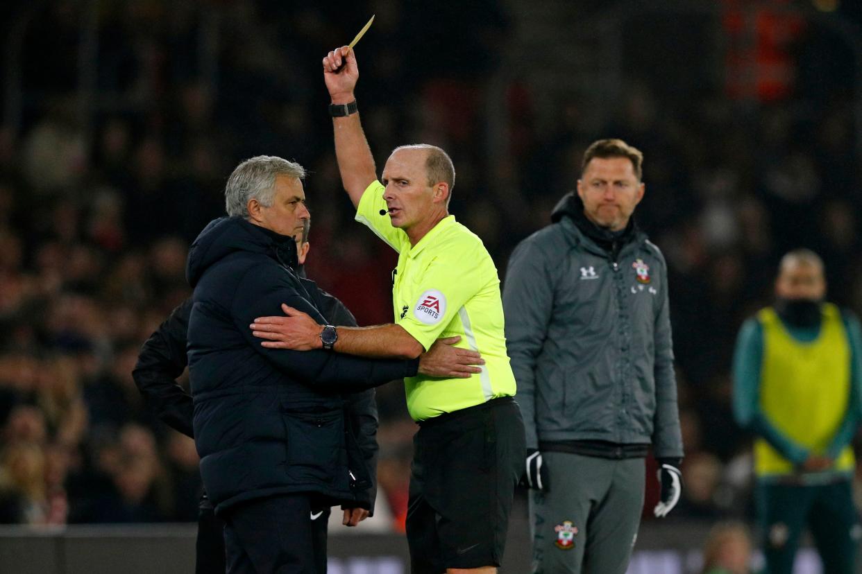  Jose Mourinho is shown a yellow card by referee Mike Dean during Wednesday's Tottenham-Southampton match. (Photo by Adrian DENNIS / AFP)