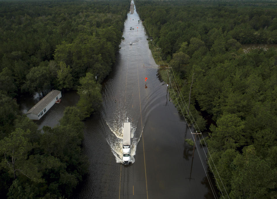 A truck drives through a flooded highway as flooding from the remnants of Tropical Storm Imelda continues in Southeast Texas on Friday, Sept. 20, 2019, in Mauriceville, Texas. (Jon Shapley/Houston Chronicle via AP)