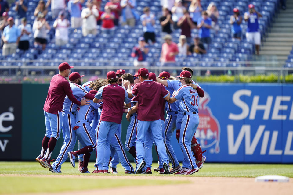 Philadelphia Phillies players celebrate after Jean Segura hit a game-winning two-run single off Atlanta Braves pitcher Chris Martin during the 10th inning of a baseball game, Thursday, June 10, 2021, in Philadelphia. (AP Photo/Matt Slocum)