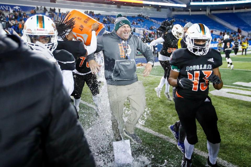 Frederick Douglass head coach Nathan McPeek is doused with water during celebrations after winning the Class 5A state championship against Bowling Green at Kroger Field on Dec. 2, 2022.