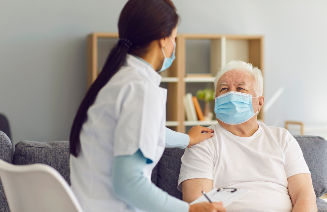 A health worker visiting a senior male patient at home.