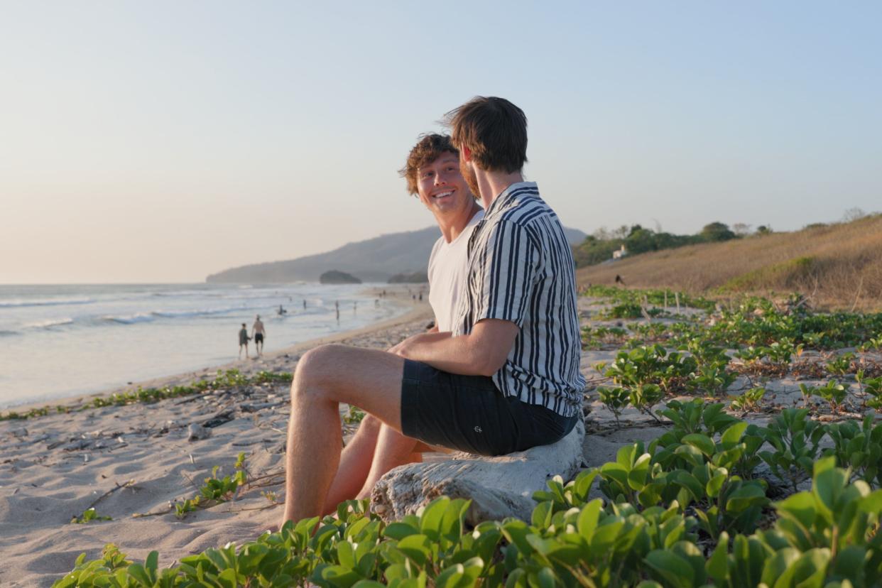 Young Gay Couple Sitting on the Beach on Vacation in Costa Rica