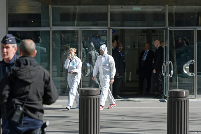 French forensic officers leave the IMF offices in Paris, after a parcel bomb exploded inside the building on March 16, 2017