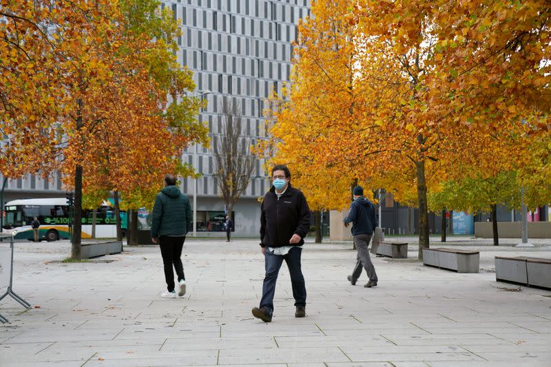 Masked people walk through Pamplona, Spain, after the Navarran local government limited all non-essential movement in and out of the region for two weeks