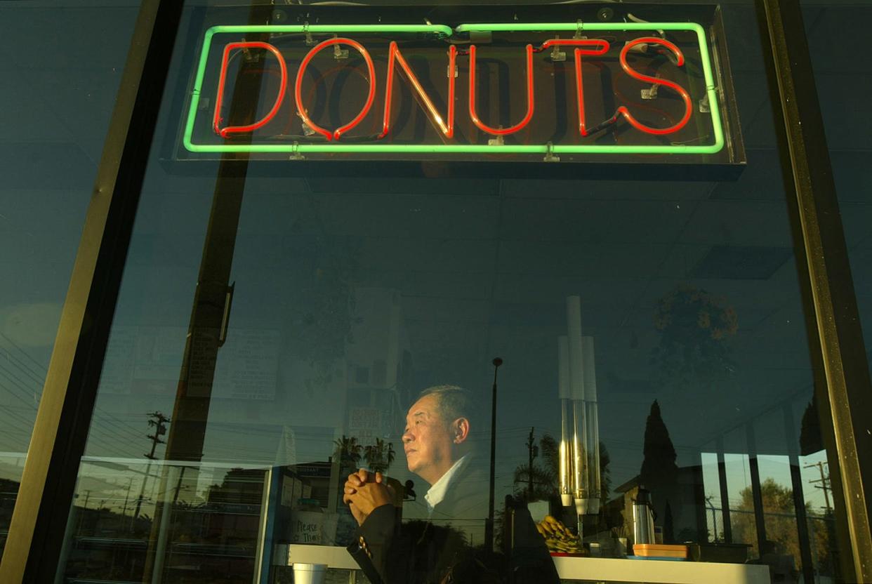 Ted Ngoy sits in one of his donut shops