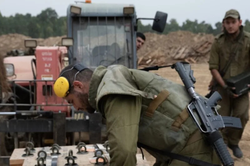 Israeli soldiers prepare a new batch of shells while shooting a Howitzer positioned on a staging area near the Gaza Strip in southern Israel on Tuesday. Photo by Jim Hollander/UPI