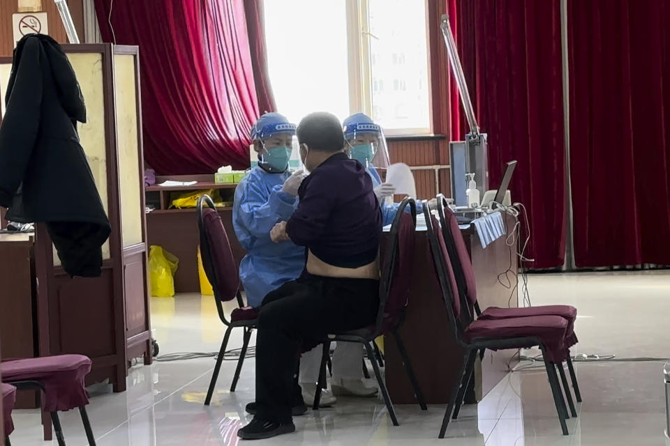 Medical workers vaccinate a man at a vaccination center in Beijing, Friday, Dec. 16, 2022. A week after China dramatically eased some of the world's strictest COVID-19 containment measures, uncertainty remained Thursday over the direction of the pandemic in the world's most populous nation. (AP Photo/Ng Han Guan)