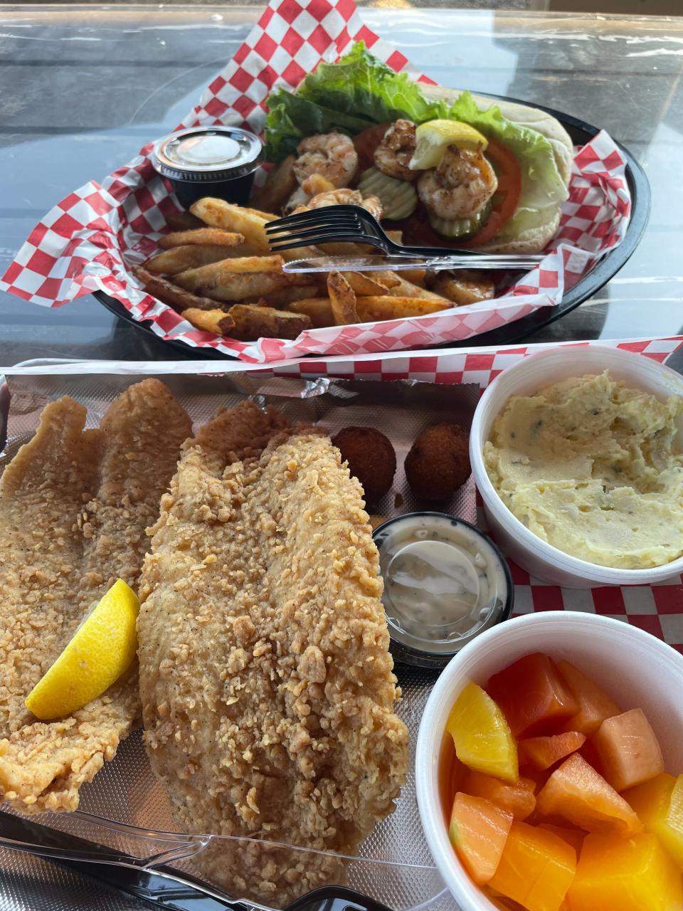 Fried catfish — two breaded filets served with my choice of two side dishes. I opted for potato salad and a fruit cup. Top: shrimp po’ boy — seasoned Gulf grilled shrimp prepared served on a bun with lettuce, tomatoes and pickles and fries. July 2022