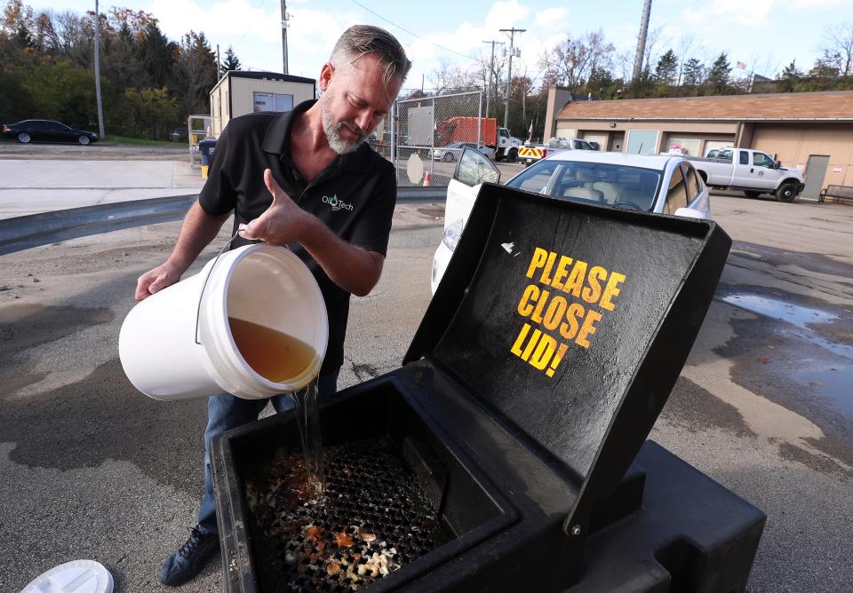 Todd Bluechel pours used cooking oil into a recycling receptacle in Louisville, Ky. on Nov. 10, 2020. Bluechel is the v.p. of sales marketing business development for Oil-Tech, a company that recycles used cooking oil.