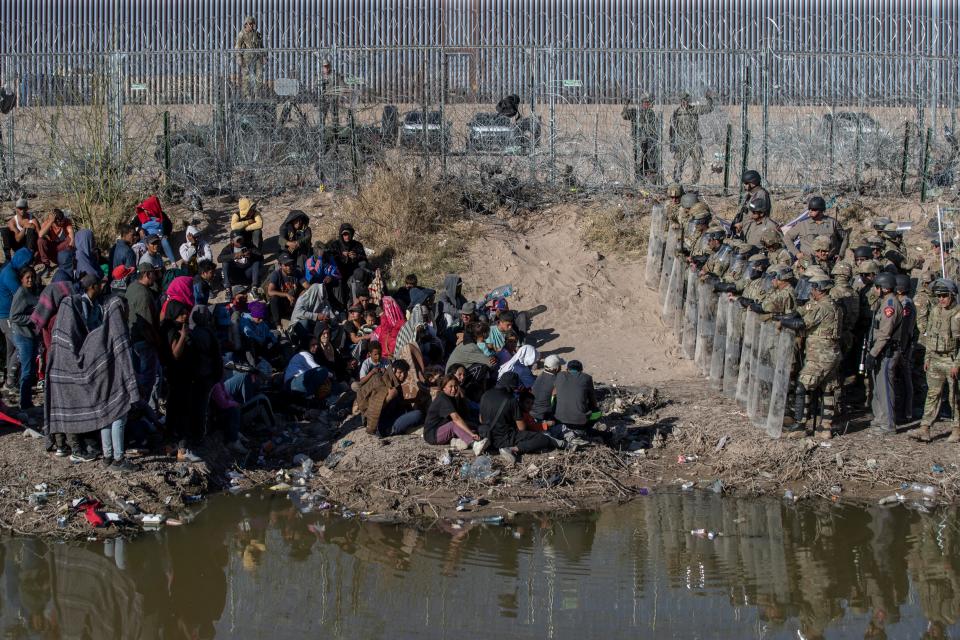 Texas National Guard and Texas State Troopers use anti-riot gear to prevent asylum seekers from entering further into U.S. territory after they crossed the Rio Grande into El Paso on March 22.