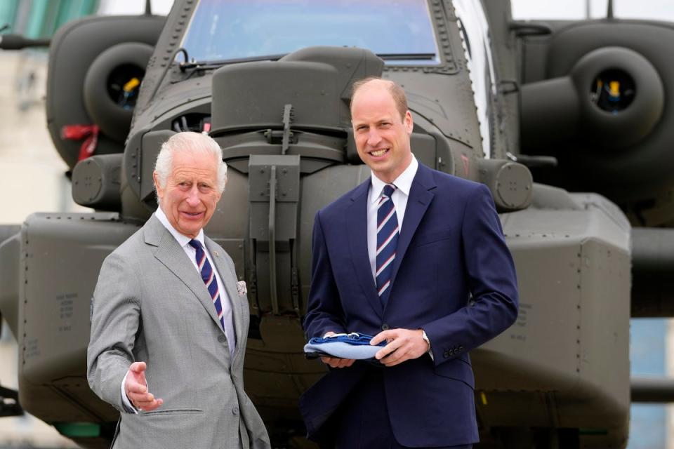 Charles and William in front of an Apache helicopter at the Army Aviation Centre on 13 May (Getty)