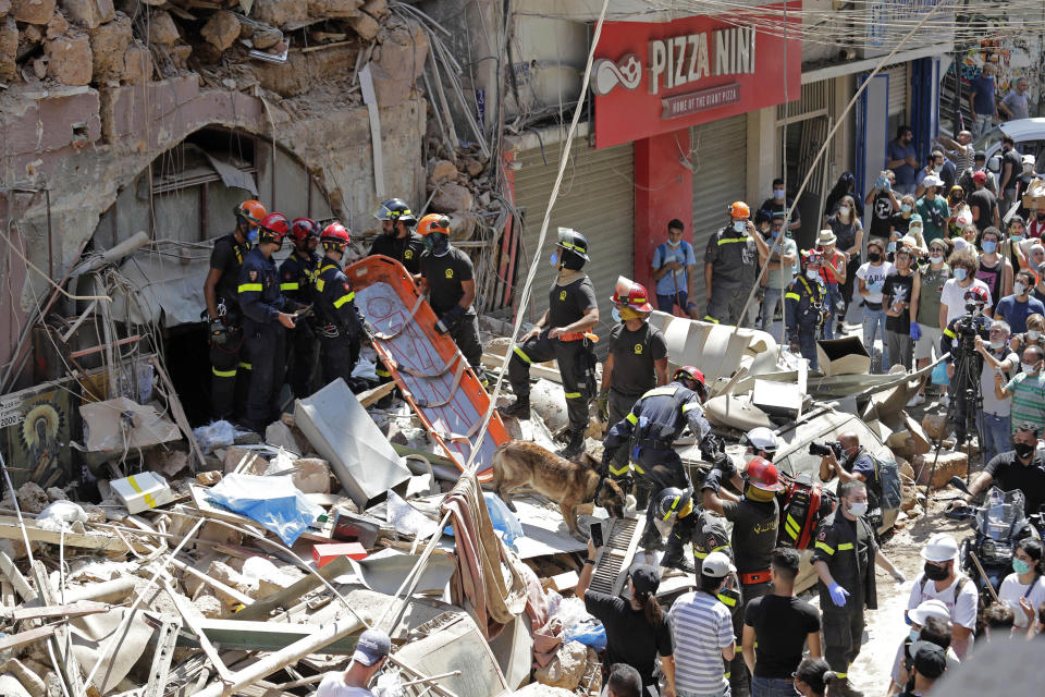 French and Lebanese firemen search in the rubble of a building after the Tuesday explosion at the seaport of Beirut, in Beirut, Lebanon, Thursday, Aug. 6, 2020. Lebanese officials targeted in the investigation of the massive blast that tore through Beirut sought to shift blame for the presence of explosives at the city's port, and the visiting French president warned that without serious reforms the country would "continue to sink." (AP Photo/Hassan Ammar)