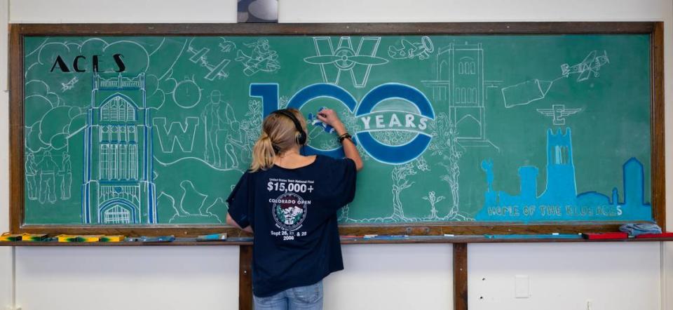 East High student Melian Miller works on a chalk drawing commemorating the 100th anniversary of the school’s opening. The school, which officially opened on October 8, 1923, is planning a number of events around the anniversary for students, alumni and the community.