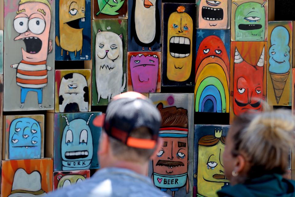 People look at art by Chris Vance on April 29, 2023, during the Festival of the Arts.