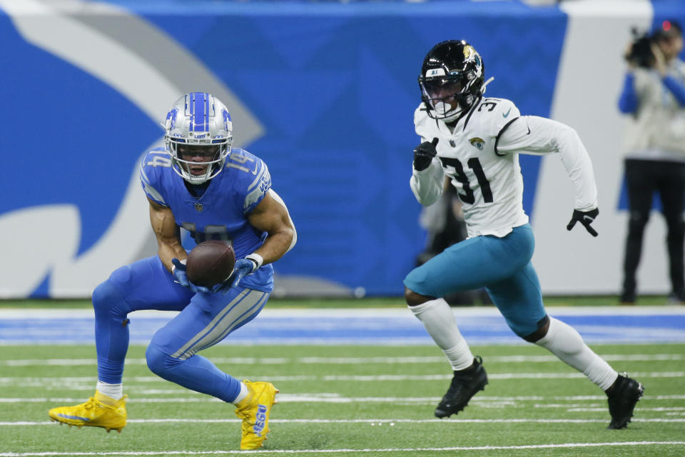 Detroit Lions wide receiver Amon-Ra St. Brown (14) makes a catch as Jacksonville Jaguars cornerback Darious Williams (31) defends during the second half of an NFL football game, Sunday, Dec. 4, 2022, in Detroit. (AP Photo/Duane Burleson)