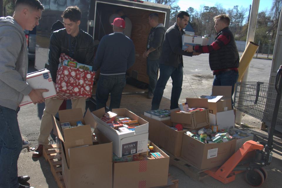 Volunteers help pack food boxes for Christmas Cheer.