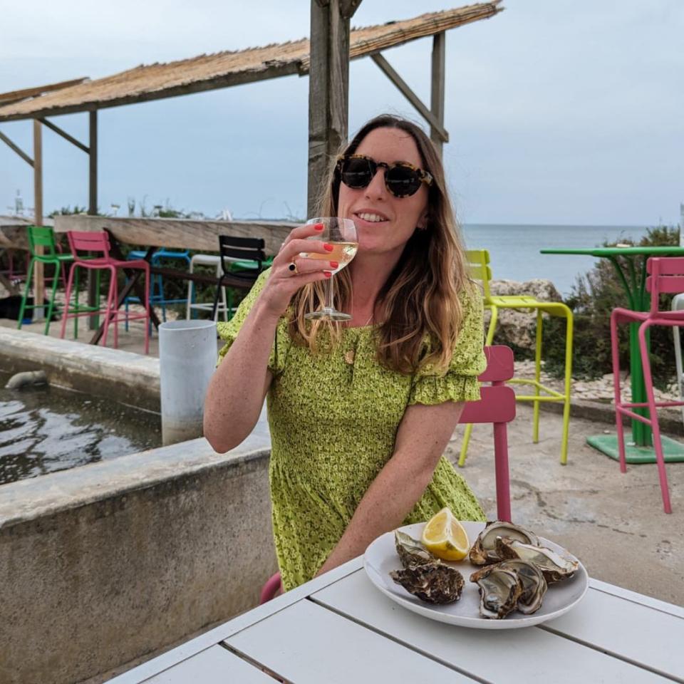 Emilee Tombs eats oysters by the sea