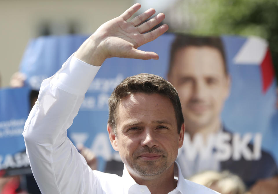 In this Thursday, July 9, 2020 photo Rafal Trzaskowski, contender in Poland's tight presidential election runoff on Sunday, July 12, 2020, waves during a rally in Raciaz, Poland. Trzaskowski is running against incumbent conservative president, Andrzej Duda, who has backing from the ruling party. Opinion polls suggest the election may be decided by a small number of votes. (AP Photo/Czarek Sokolowski)