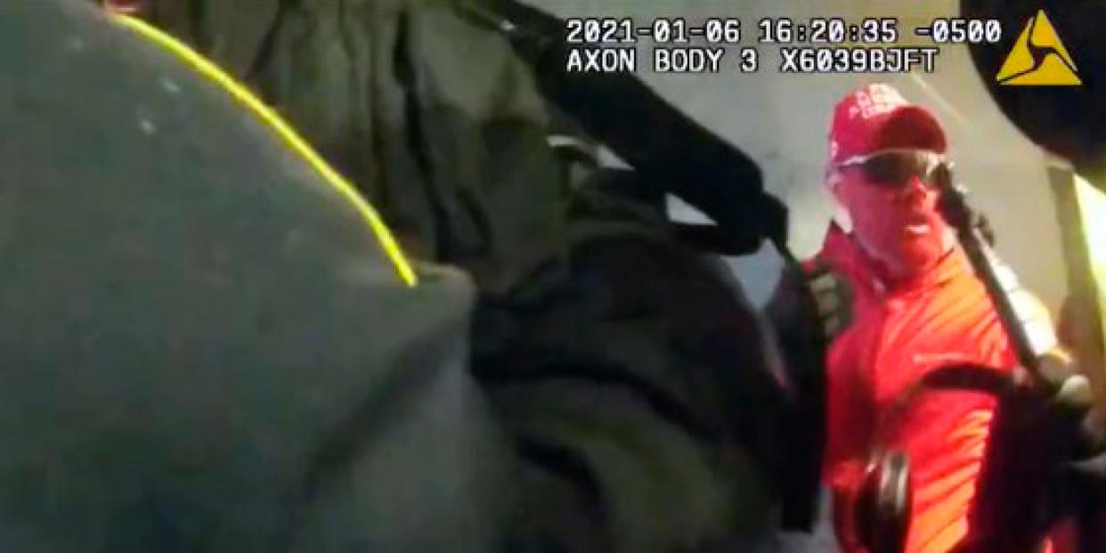 body cam footage featuring man all in red on the right, partially obscured by what looks to be a police officer's torso