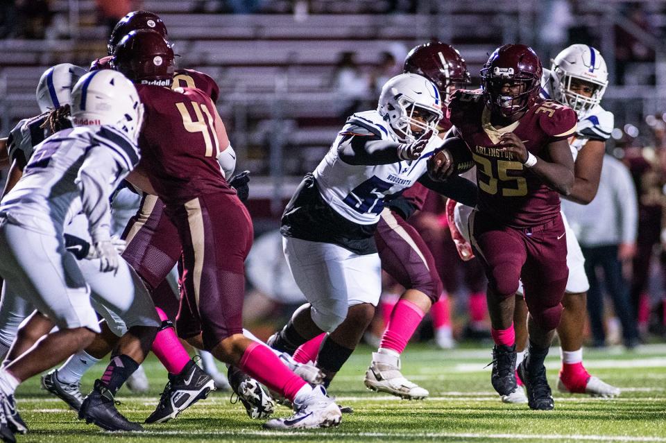 Arlington's Daeon Lynch, right, runs through New Rochelle defenders during the Section 1 class AA quarterfinal football game at Arlington High School in Freedom Plains, NY on Friday, October 28, 2022. Arlington defeated New Rochelle. KELLY MARSH/FOR THE POUGHKEEPSIE JOURNAL