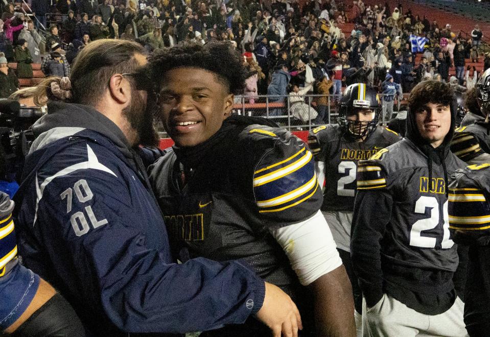 Toms River North star junior quarterback/defensive back Micah Ford, who was the Mariners' spark plug all season on both sides of the ball, is hugged by a Toms River North assistant coach in the final seconds of the Mariners' 28-7 win over Passaic Tech Sunday in the NJSIAA Group 5 championship game.