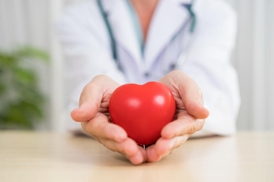 doctor holds stress relief ball in the shape of a heart.