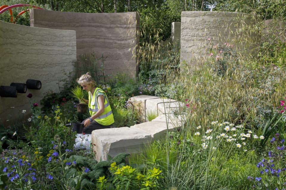 A member of the team works The Mind Garden designed by Andy Sturgeon during build up to the show (RHS / Luke MacGregor/PA)