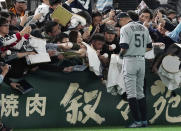 Seattle Mariners right fielder Ichiro Suzuki gives his autograph to fans prior to a pre-season exhibition baseball game between the Mariners and the Yomiuri Giants at Tokyo Dome in Tokyo Sunday March 17, 2019. (AP Photo/Eugene Hoshiko)