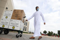 Saher Khan rolls boxes of treats to hand out during a drive-through Eid al-Fitr celebration outside a closed mosque in Plano, Texas, Sunday, May 24, 2020, during the coronavirus pandemic. (AP Photo/LM Otero)