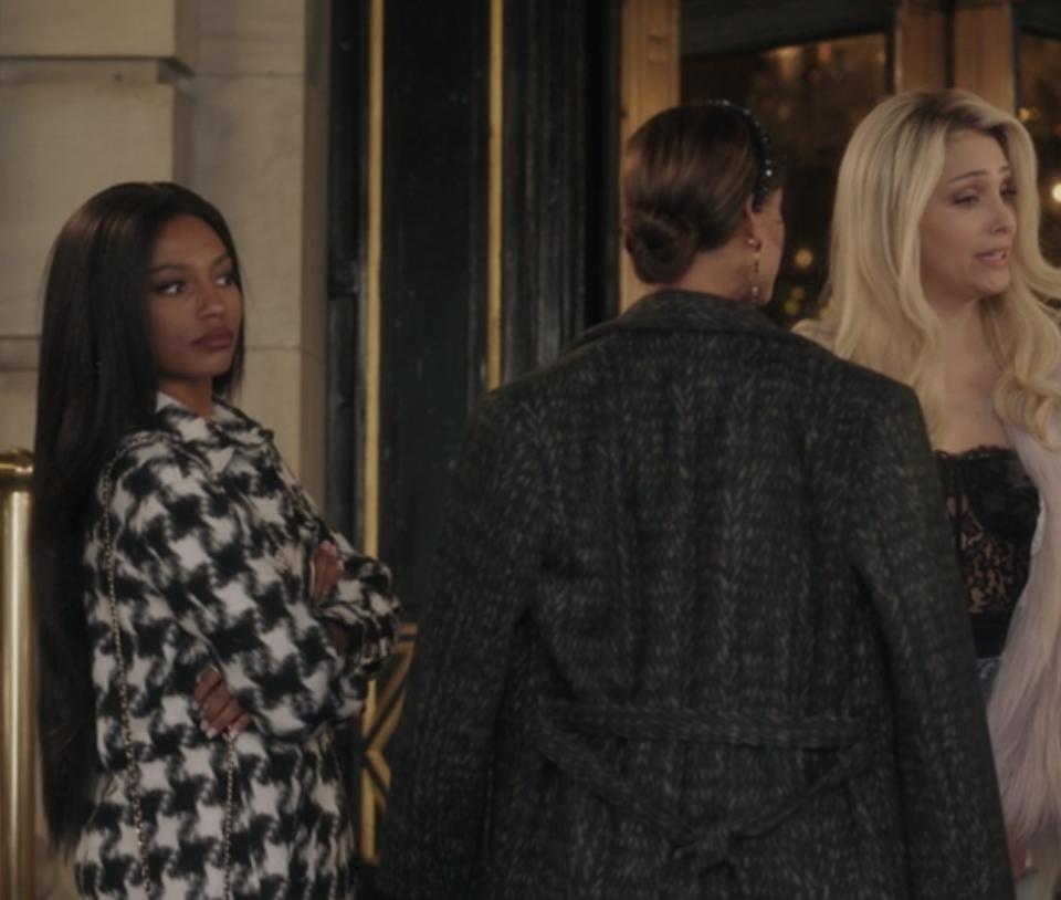 Monet de Haan (reboot) wearing a black and white houndstooth jacket.