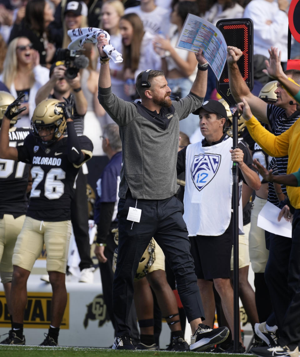 Colorado interim head coach Mike Sanford, center, exhorts the crowd in the first half of an NCAA college football game against California in Folsom Field Saturday, Oct. 15, 2022, in Boulder, Colo. (AP Photo/David Zalubowski)