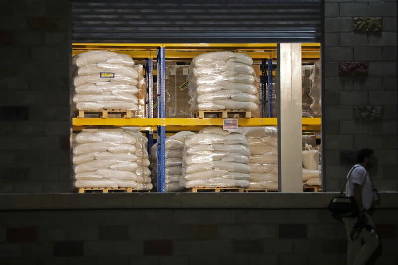 FILE PHOTO: A man walks past aid at a warehouse where international humanitarian aid for Venezuela is being stored, during a visit by U.S. Secretary of State Mike Pompeo and Colombia’s President Ivan Duque, in Cucuta