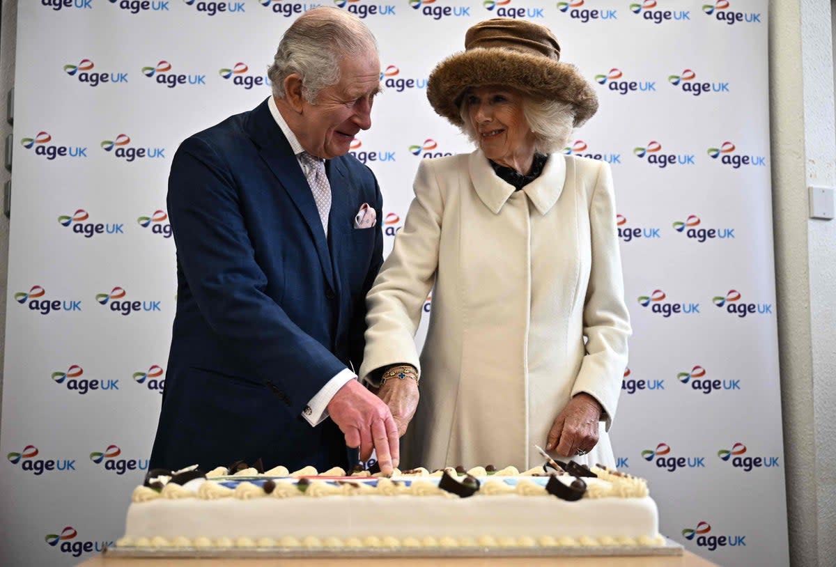 Charles and Camilla cut a cake during an afternoon tea with volunteers and service users of the charity organisation Age UK at Colchester Library (POOL/AFP via Getty Images)