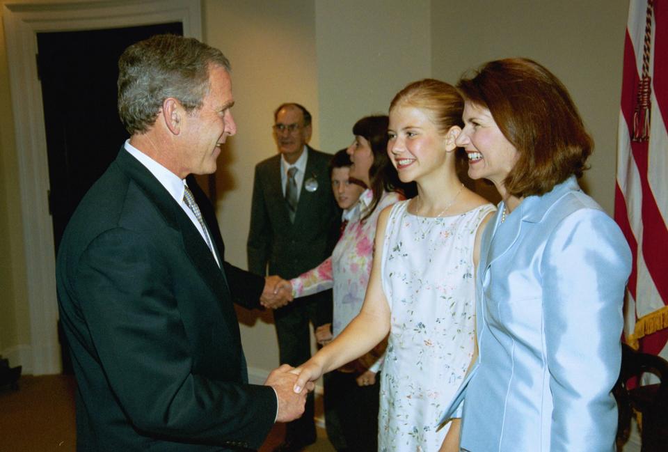 President George W. Bush greets Elizabeth Smart and her mother at the White House on April 30, 2003 before he signed a law to help states nationwide implement Amber Alerts.