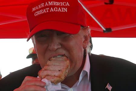 Republican presidential candidate Donald Trump eats a pork chop at the Iowa State Fair during a campaign stop in Des Moines, Iowa, United States, August 15, 2015. REUTERS/Jim Young