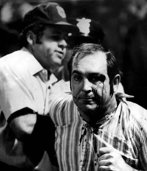 Umpire Joe Brinkman leads an unidentified fan off the field during the riot on 10-cent beer night on June 4, 1974, at Cleveland Stadium. Hundreds of unruly fans disrupted the game between Cleveland and Texas. It was declared a forfeit victory for the Rangers.